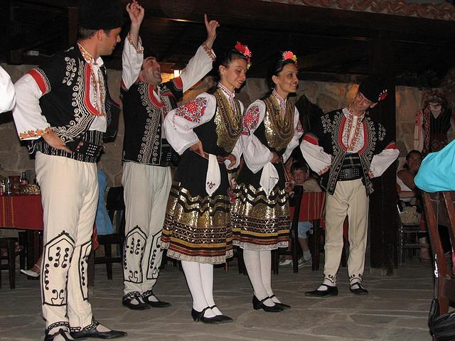 Take a bow (c) Pudpuduk by creative commons Dansers in traditionele Bulgaarse kleding buigen voor hun publiek.