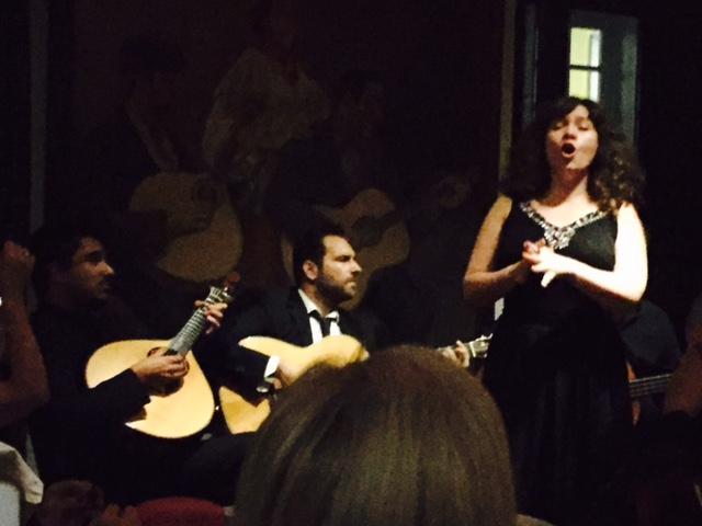 Fado in Lissabon (foto KarenD) Een fadozangeres begeleid met Portugese en klassieke gitaar. Op de achtergrond een schilderij met precies hetzelfde tafereel.