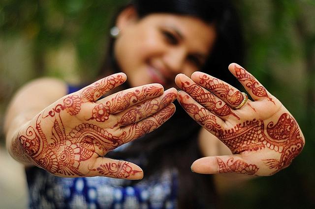 (c) Abhijit Chendvankar by creative commons Een jonge vrouw pronkt met haar fraai beschilderde handen.
