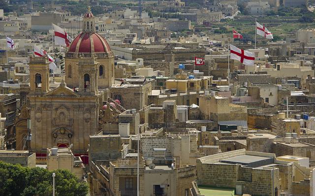 Victoria, Malta (c) Martin Lopatka by creative commons Zicht op de stad, met veel Maltese vlaggen en de rode dakkoepel van de kathedraal van Gozo.