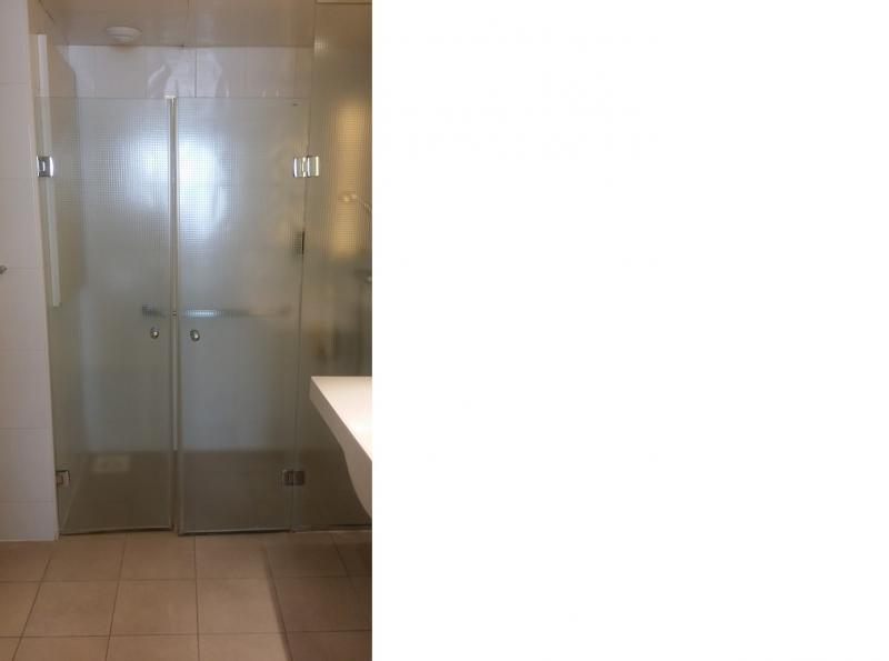Drempelloze douchekabine met dubbele glazen draaideur.
