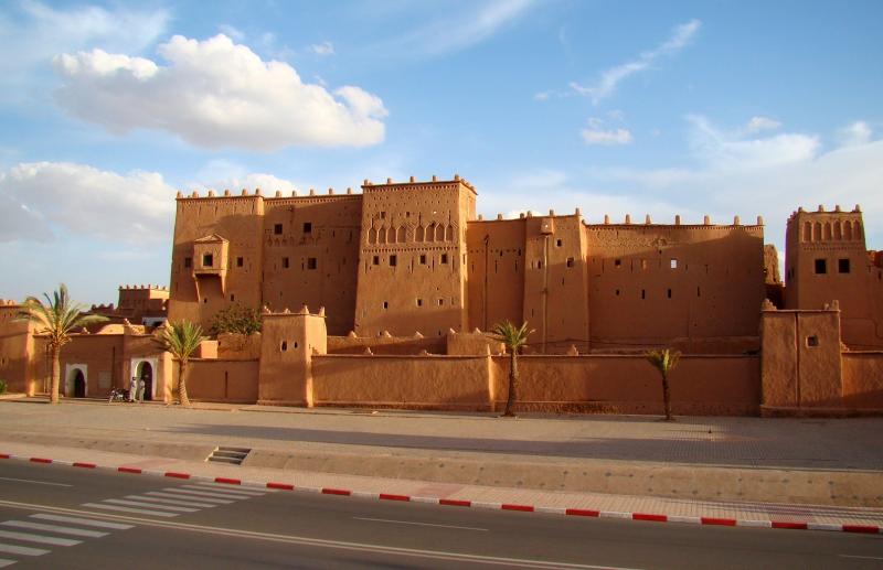 De kasbah is een groot zandstenen gebouw met veel kleine raampjes.