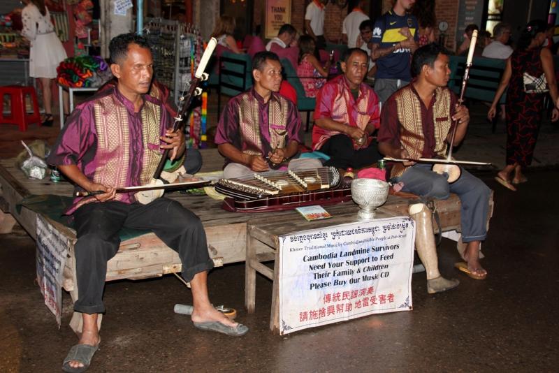 Een groepje mensen met een handicap bespelen traditionele muziekinstrumenten.