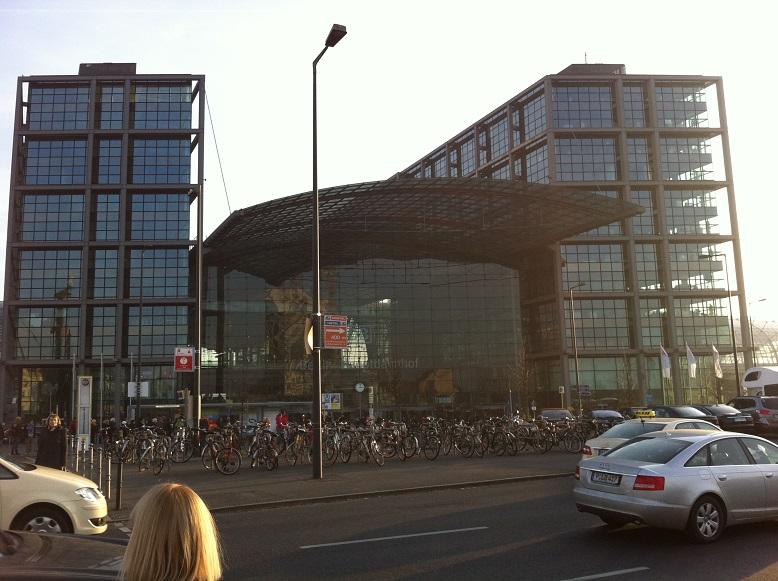 De gevel van het station bestaat grotendeels uit glas. Veel fietsen aan de voorkant: dit is fietstad Berlijn.