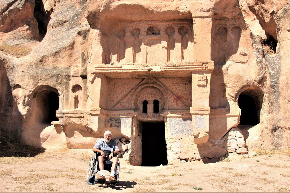 Jozef poseert voor het klooster van Açik Saray, dat in de rotsen uitgehouwen is.