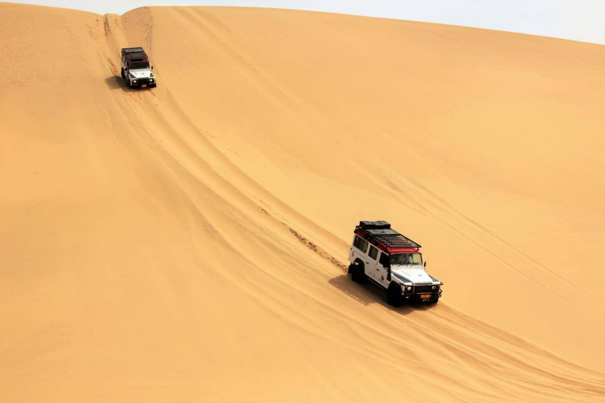 Auto's rijden dwars door de woestijn.