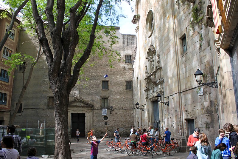 Plaça de Sant Felip Neri is op zich een onopvallend plein waar bewoners en bezoekers rond een boom komen verpozen.