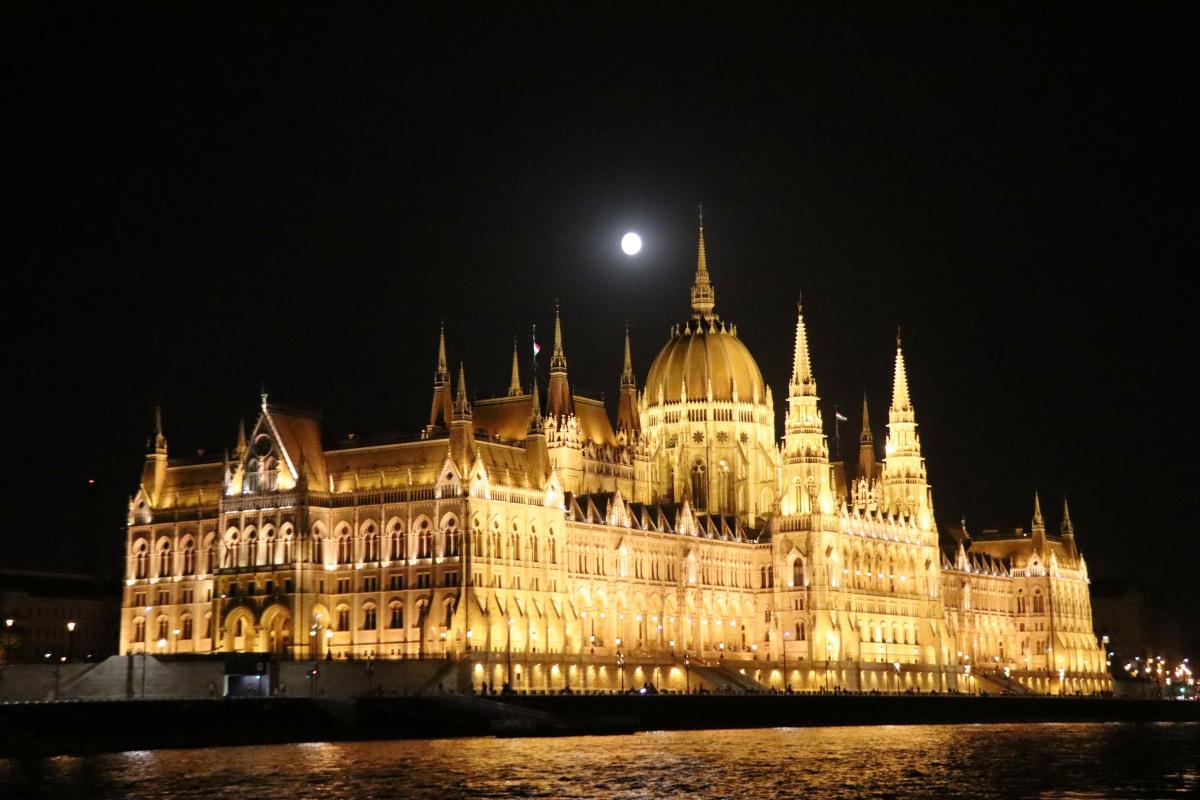 Het parlementsgebouw aan de oever van de Donau bij nacht.