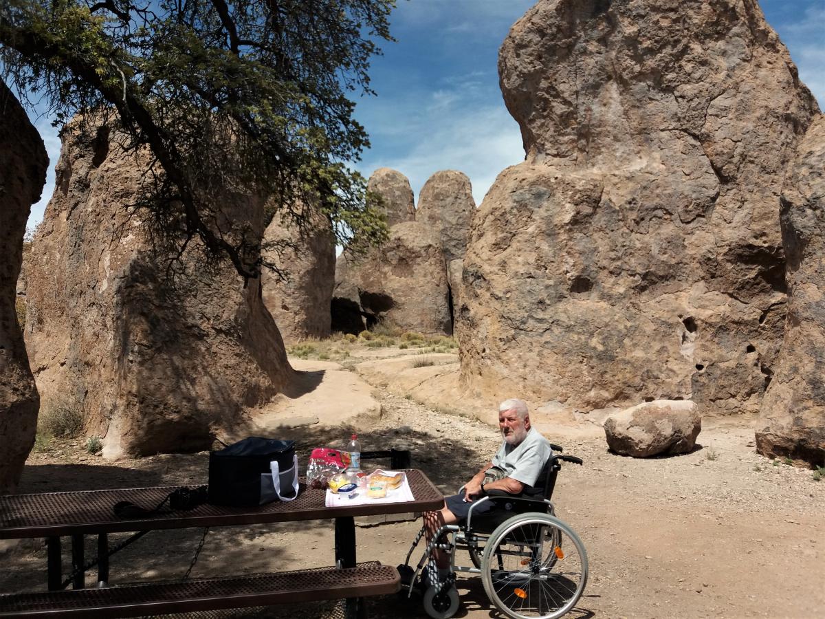 Jozef aan een picknicktafel tussen de rotsen.