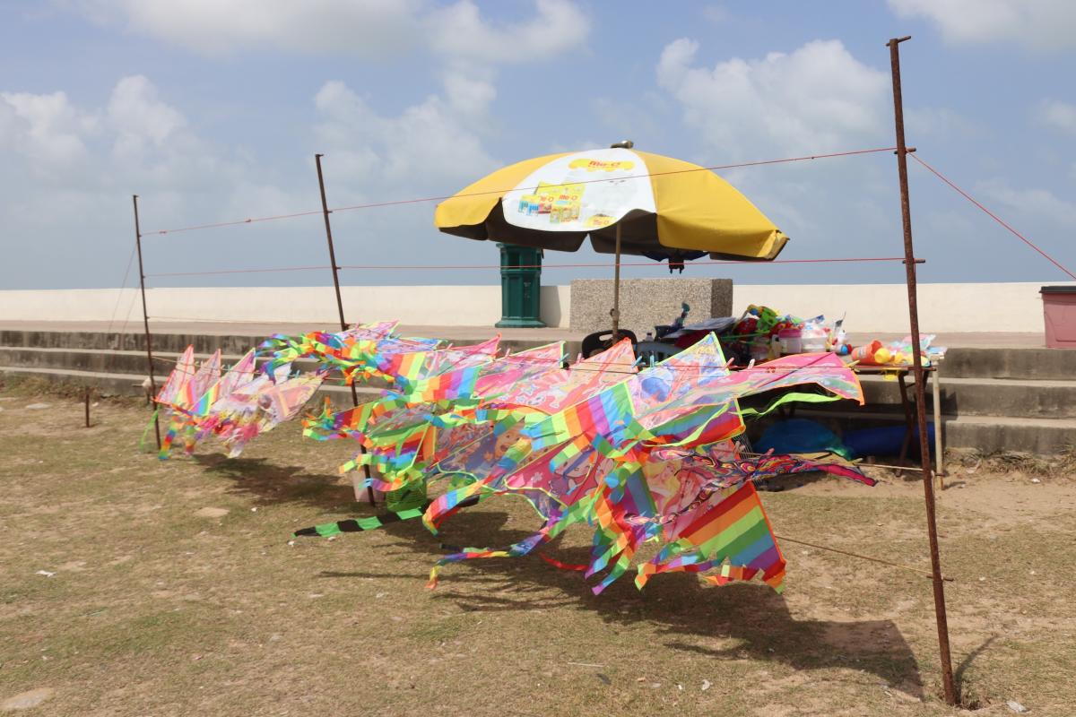 Verhuurstandje van kleurige vliegers op het strand.