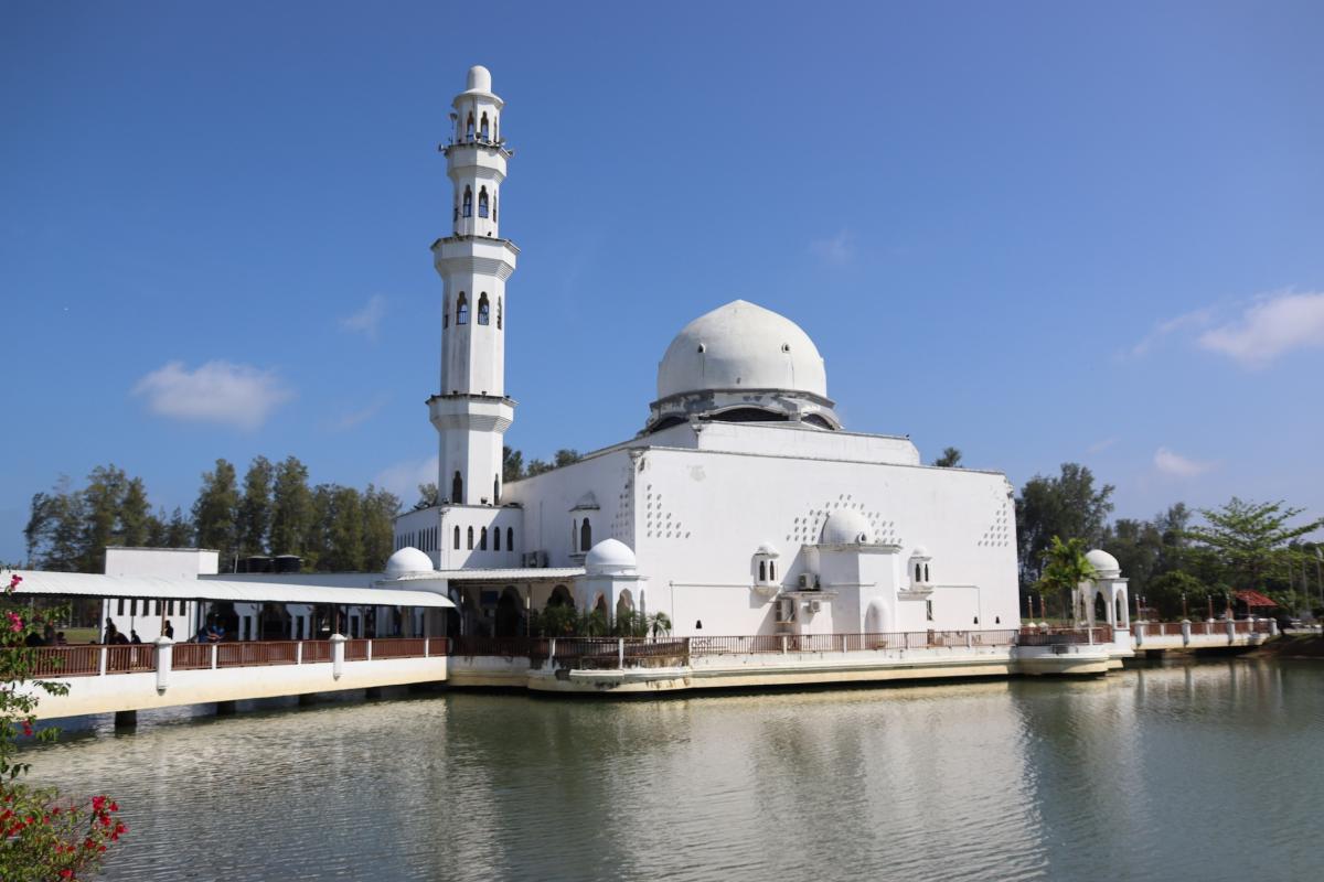 Volledig witte moskee, met minaret en koepeldaken.