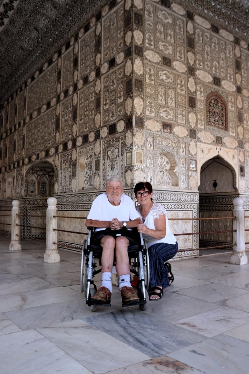 Jozef en zijn echtgenote in het Shees Mahal, versierd met spiegeltjes en inlegwerk. Jozef zit in een manuele rolstoel.