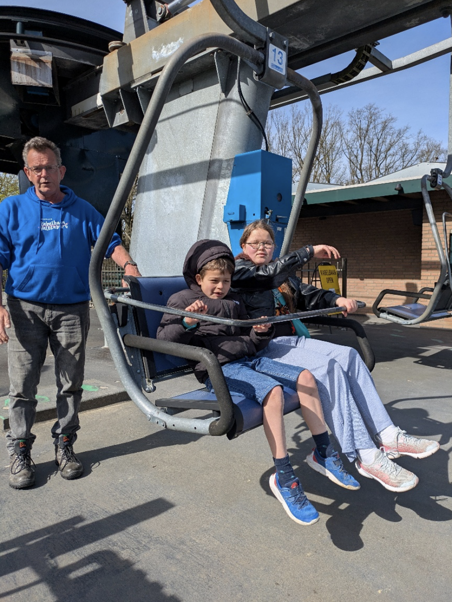 Zoon en dochter vertrekkensklaar in de stoeltjeslift.